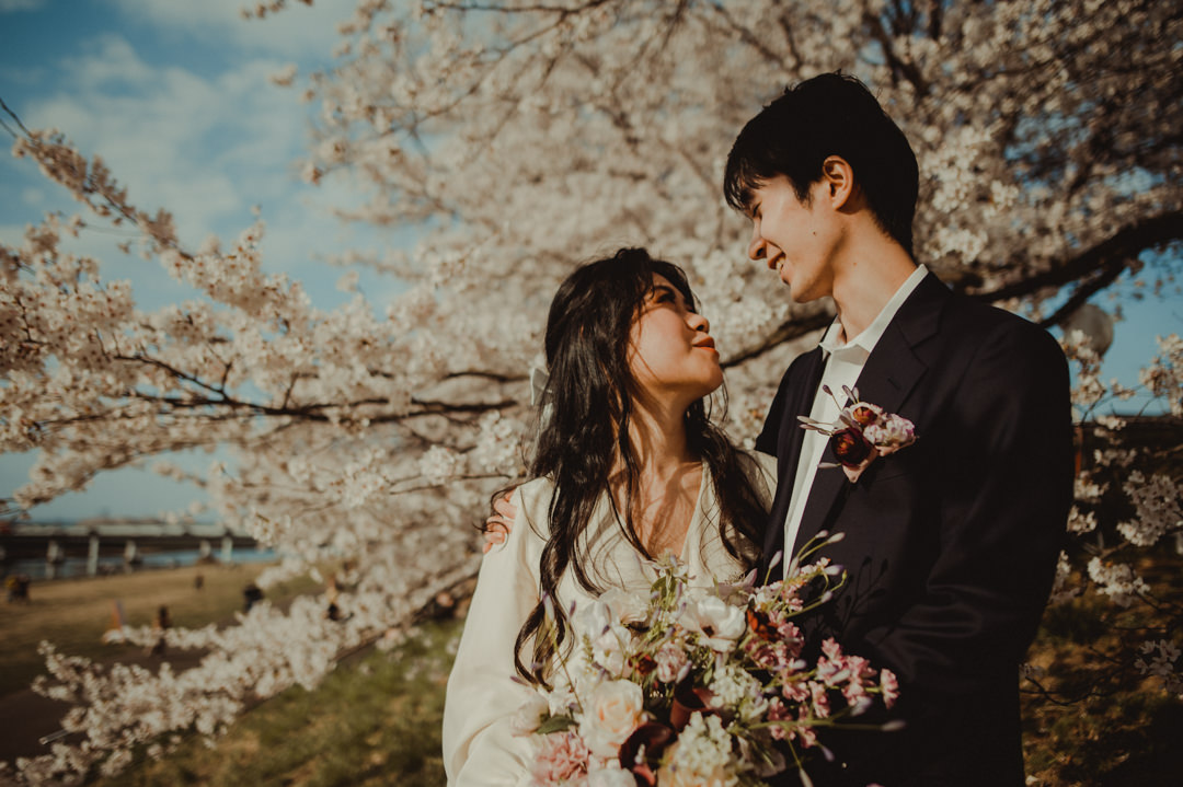 Couple in a lover's stare in front of a cherry blossom in Japan