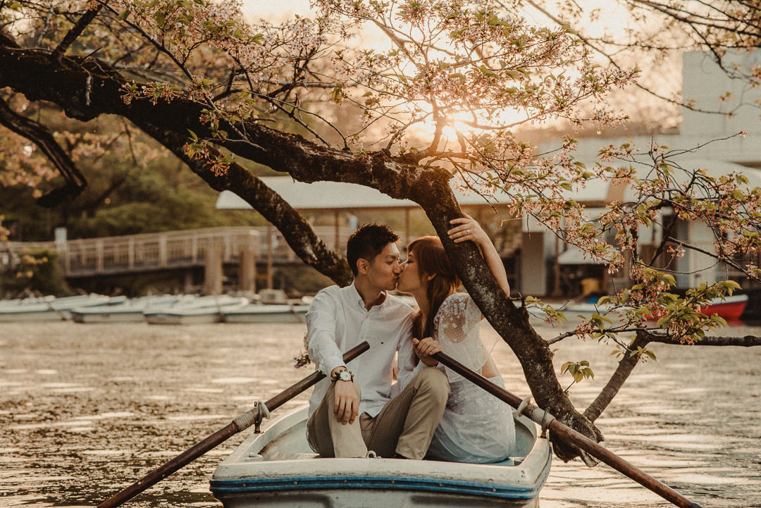Couple kissing in the boat holding a  tree