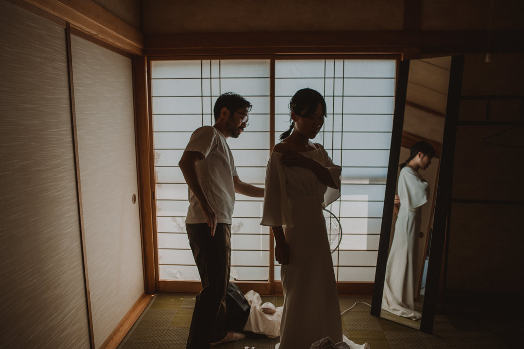 The couple helping each other get dressed during their island elopement in Japan