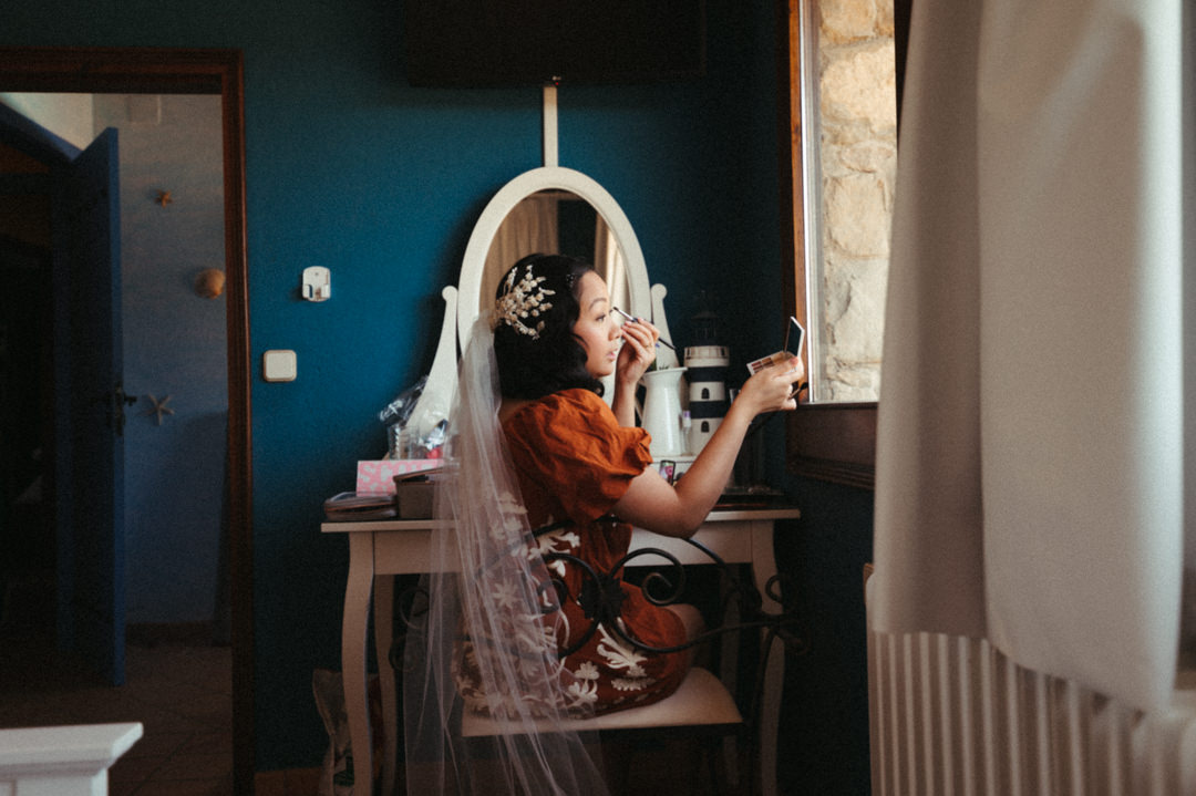 Elope in Barcelona - Bride doing wedding makeup