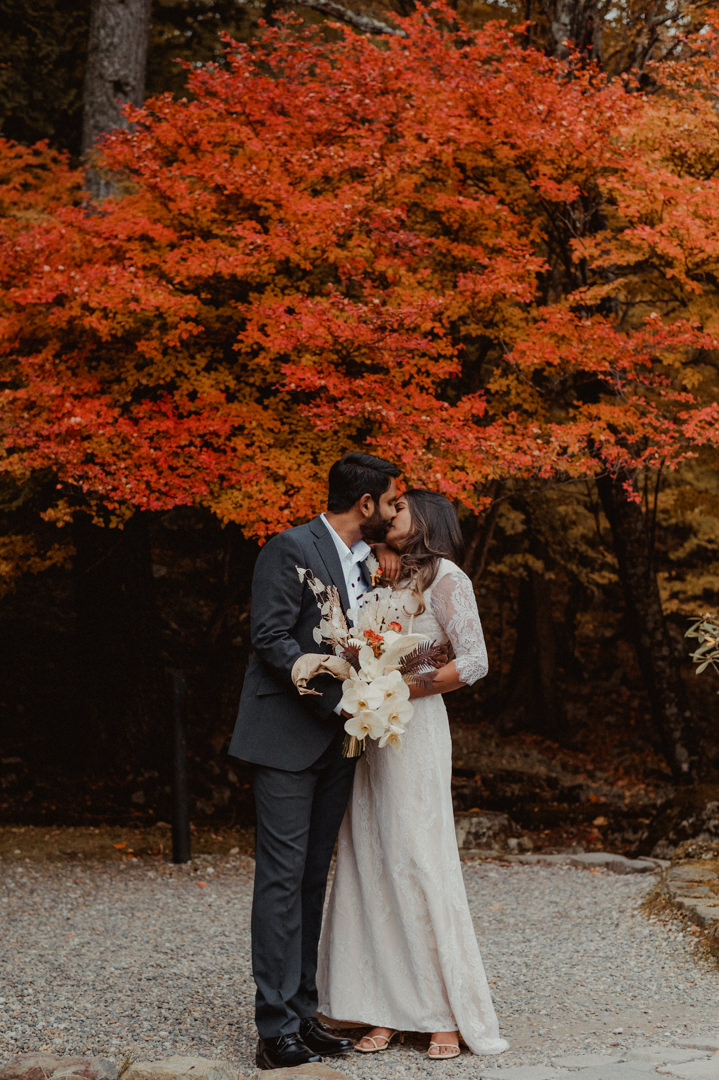 Couple kissing on their fall elopement in Japan before the wedding ceremony