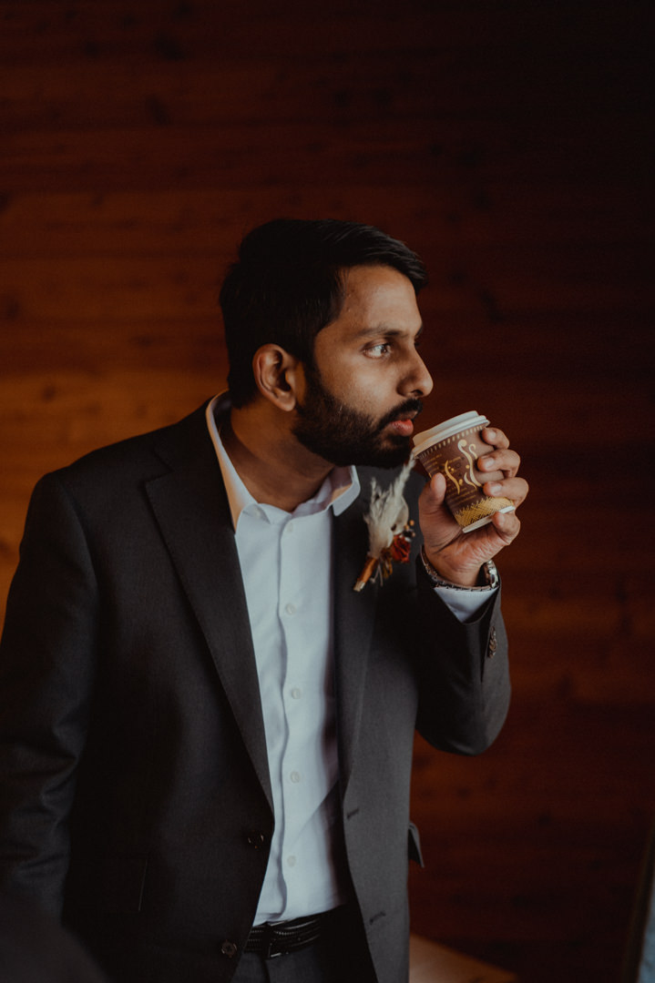 Groom drinking coffee on their fall elopement in Japan