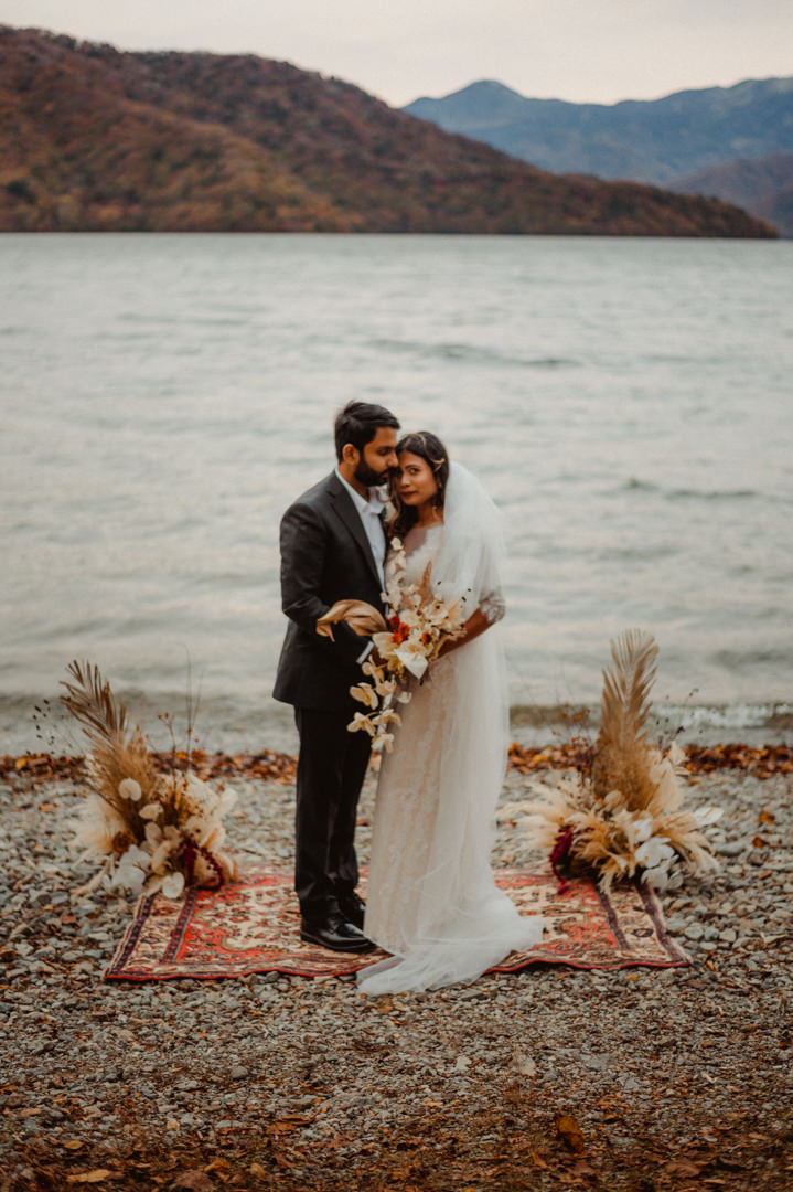 Couple snuggling at the lake before wedding ceremony on their fall elopement in Japan