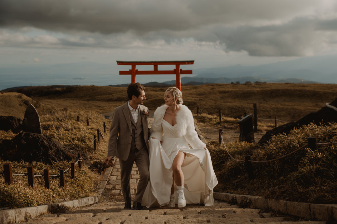 Hakone Elopement - couple is descending the stairs in front of the red torii