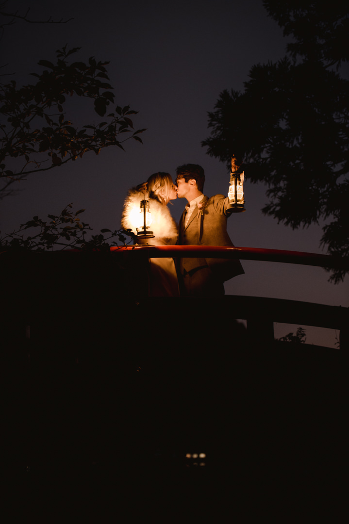 Hakone Elopement - couple is kissing and holding lanterns on the red bridge