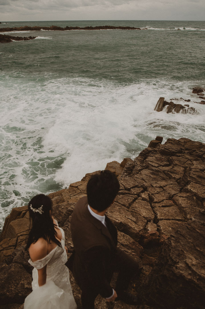 Japan Roadtrip Elopement - Couple is watching the wave from the cliff