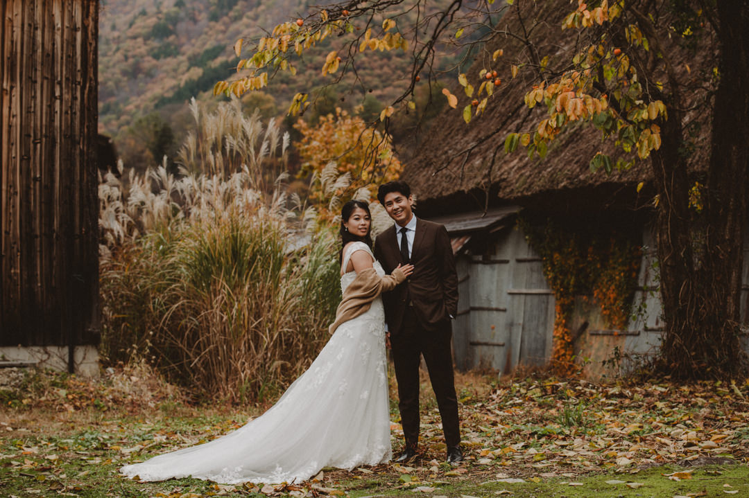 Japan Roadtrip Elopement- couple surrounded by autumn leaves and pampas grass