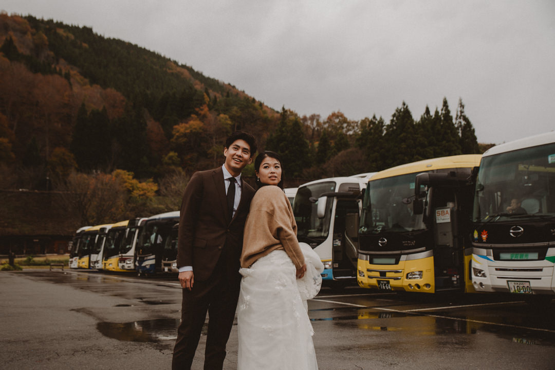 Japan Roadtrip Elopement- Couple standing in front of tourist busses