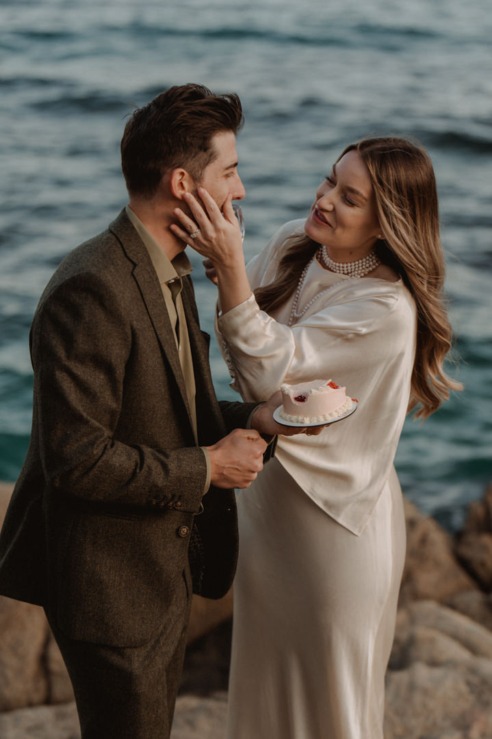 marimurtra elopement - couple eating wedding cake together 