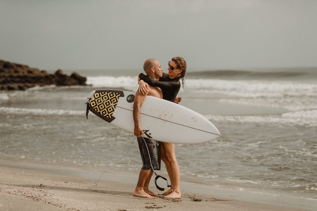 Surfer Elopement in Japan - Couple hugging on the beach after surfing