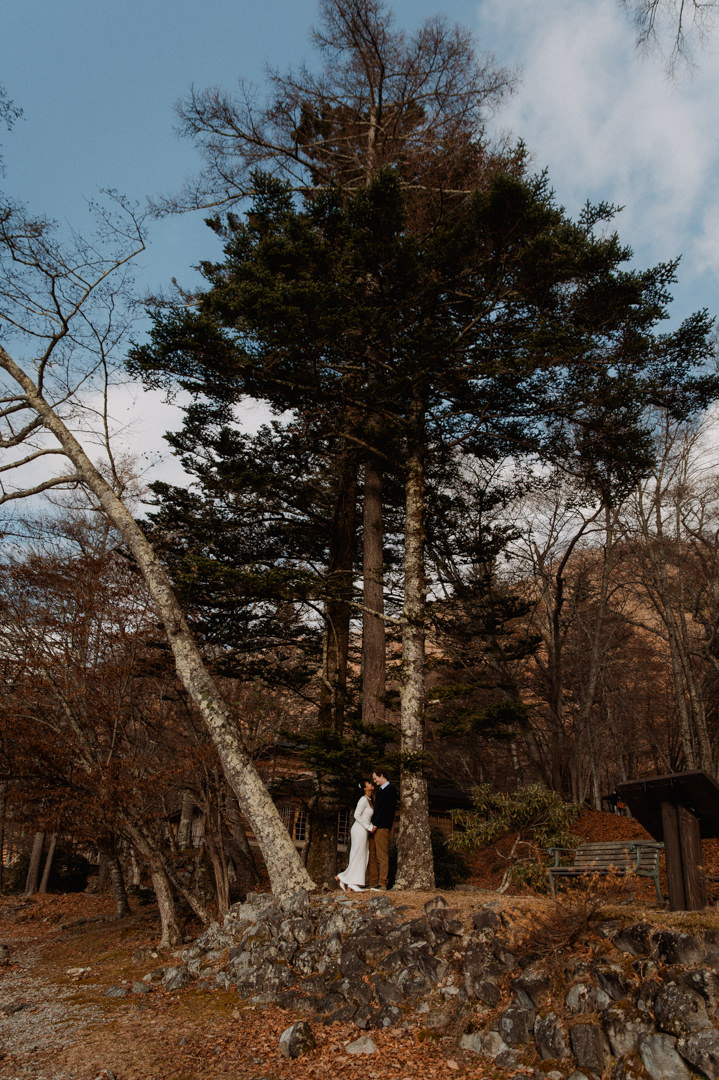 laid-back elopement in japan - couple standing between two big trees