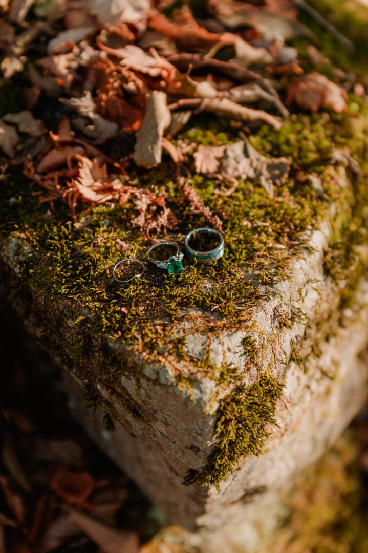 laid-back elopement in japan - wedding rings on the rock covered with moss    