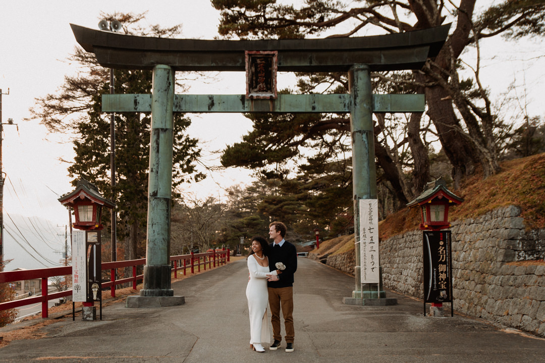 laid-back elopement in japan - couple standing in front of Torii 