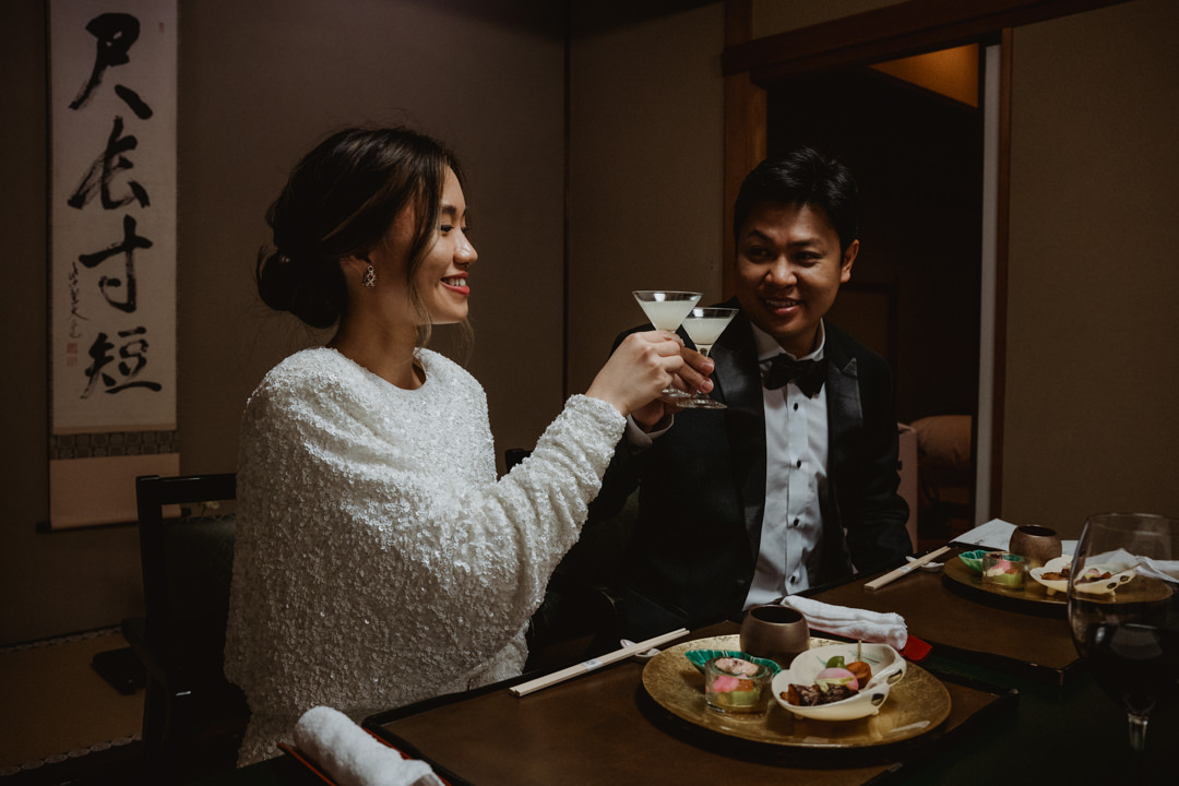 Couple toasts during the dinner, rainy day elopement in Japan