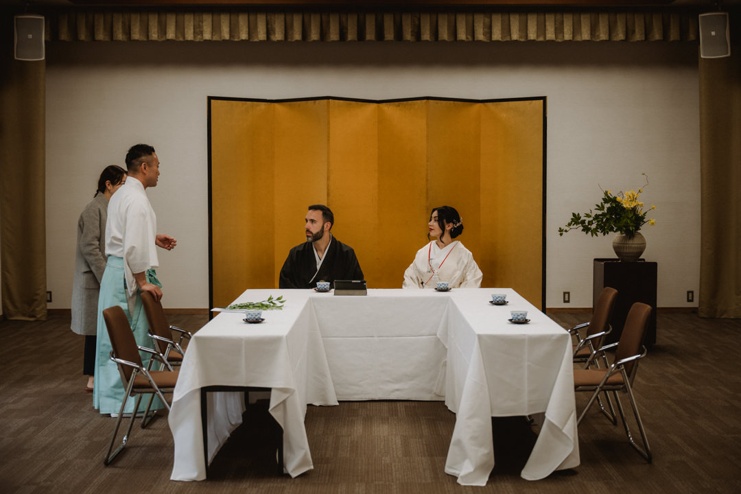 The couple listens to an explanation about the Shinto wedding ceremony. Kyoto Kimono Elopement.