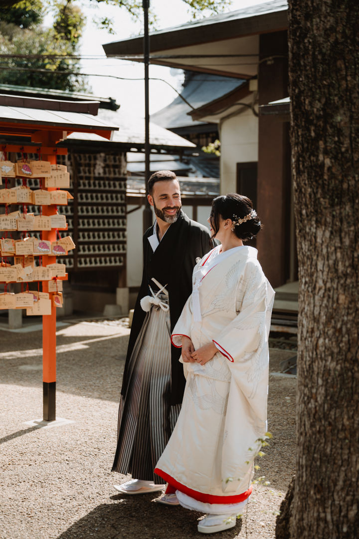 The couple takes a photo on the Shrine grounds. Kyoto Kimono Elopement.