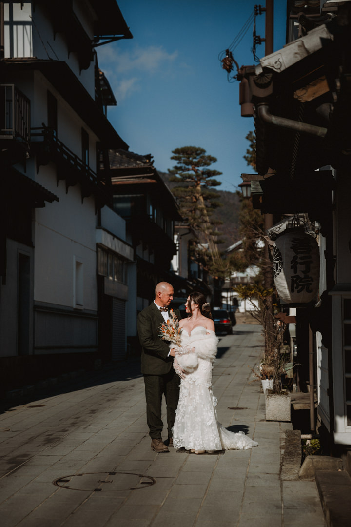 The couple has a photo shoot in Nagano City. Nagano Snow Elopement
