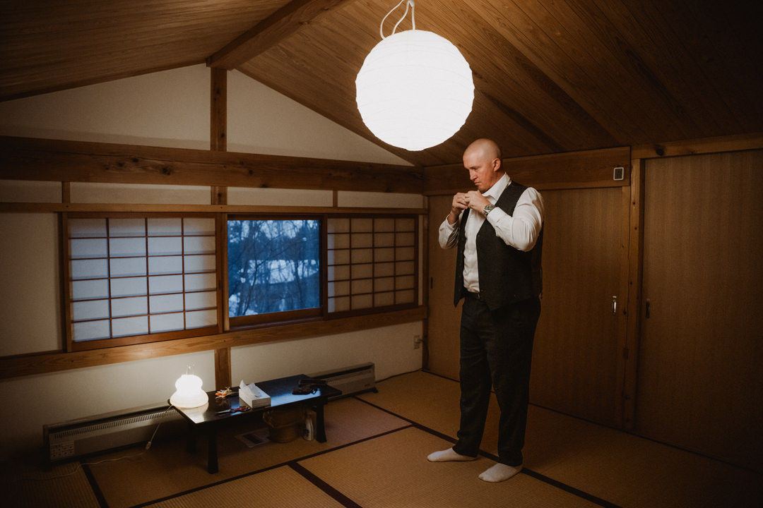 The groom gets ready at their accommodation. Nagano Snow Elopement