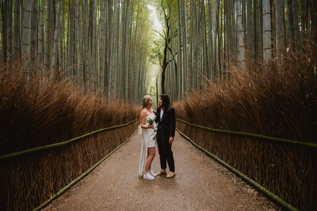 The couple takes a photo in a bamboo forest, a same sex elopement in Japan.